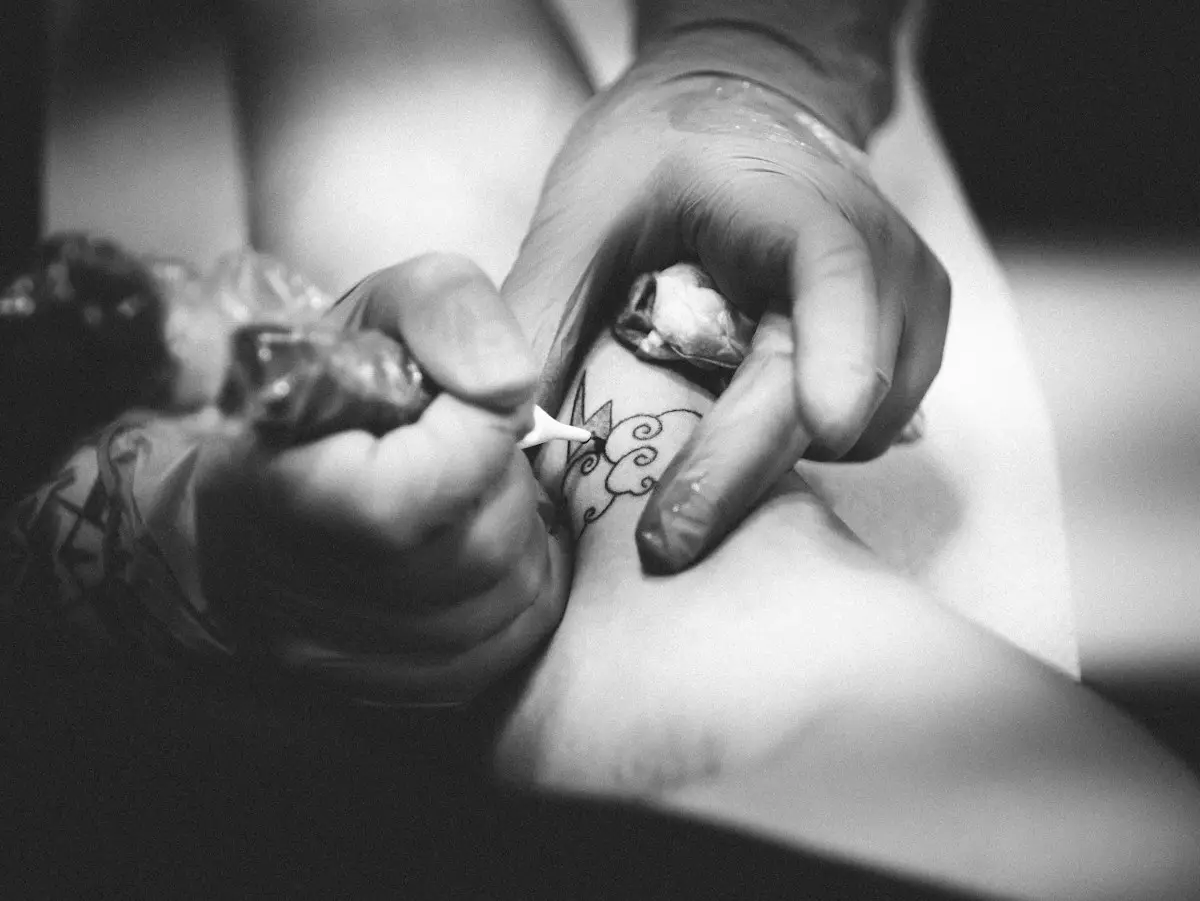 Händer i handskar tatuerar en blomma