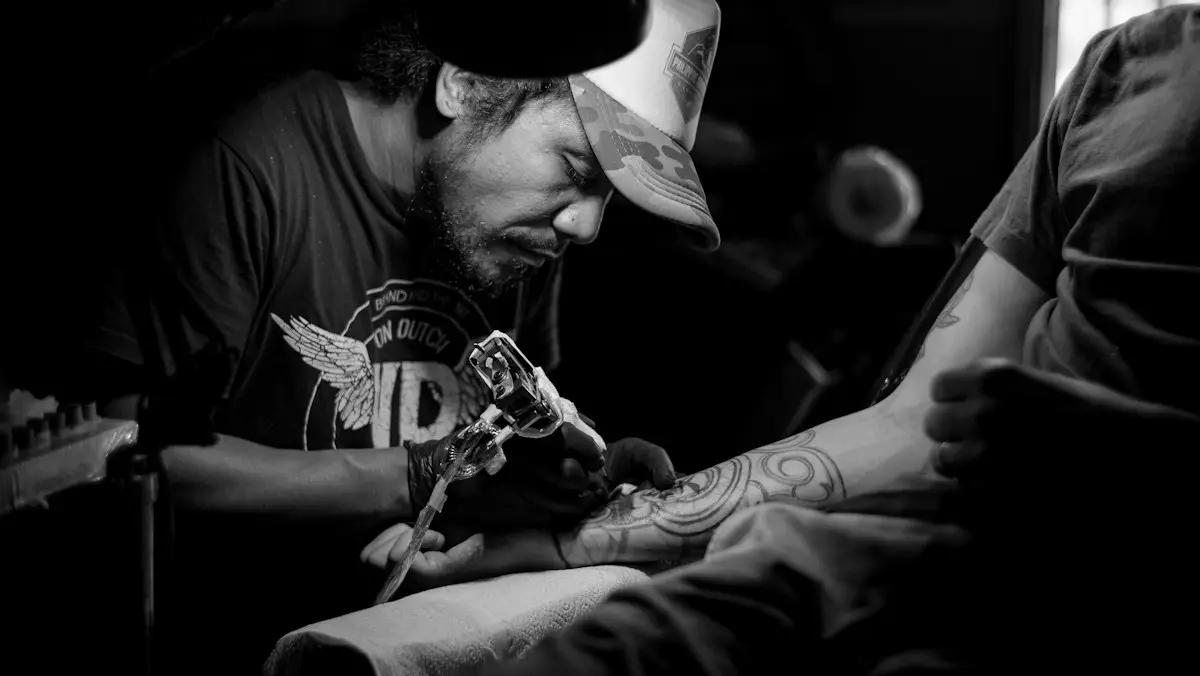En tatuerare arbetar koncentrerat på en arm