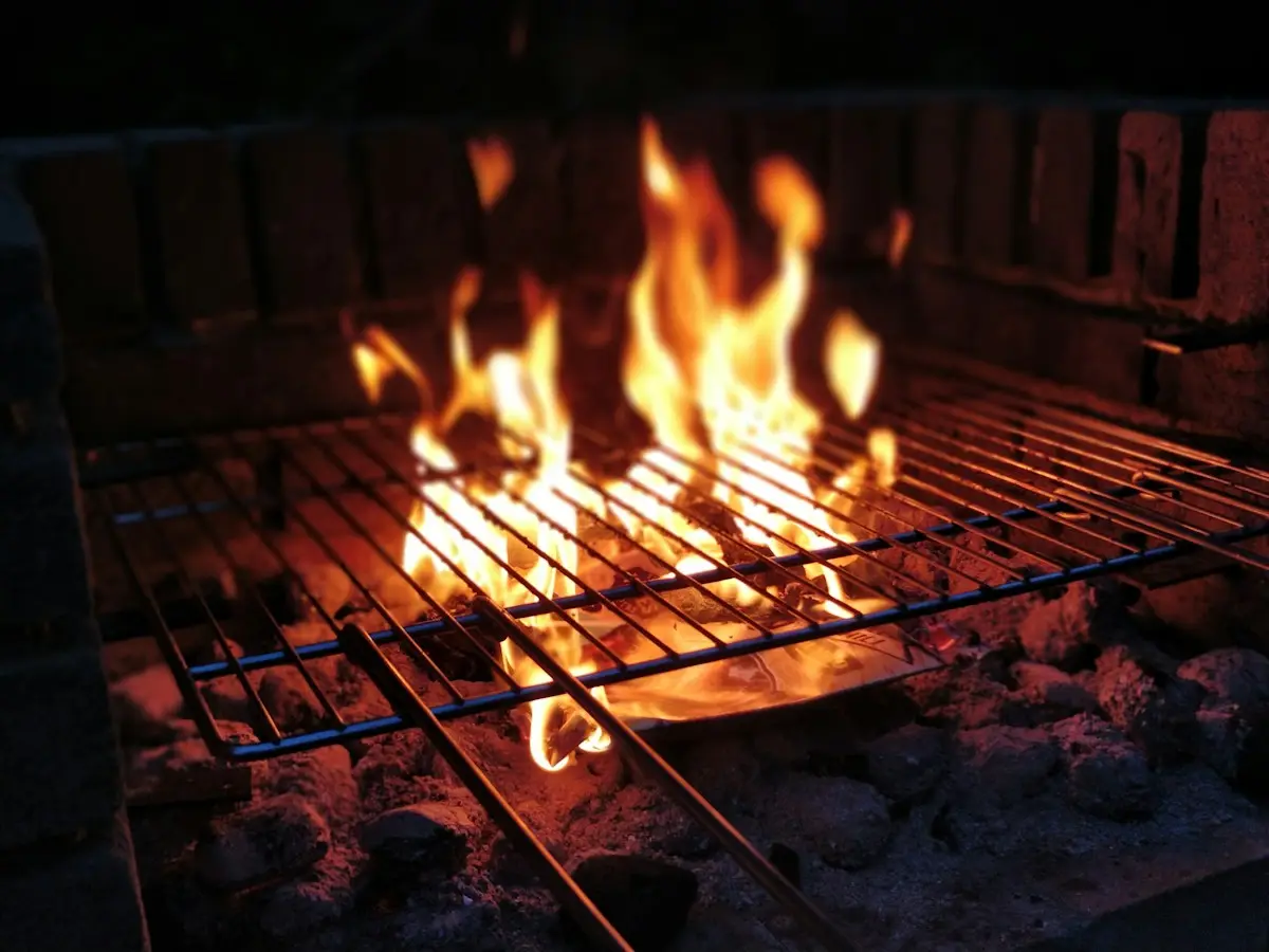 Lågor över ett galler i en murad grill