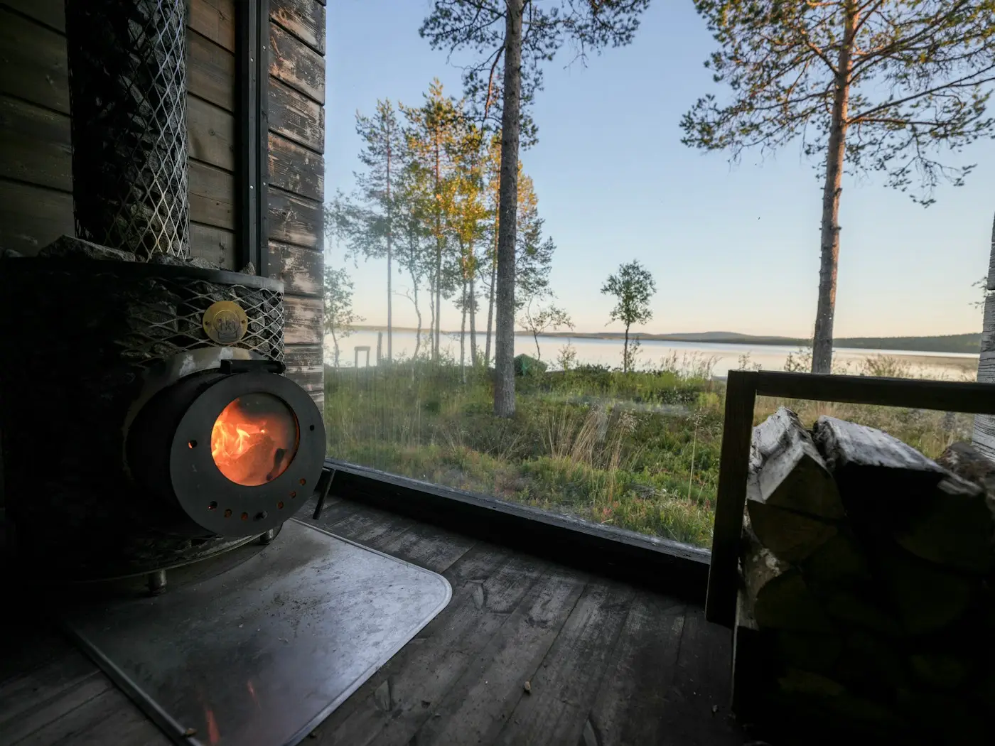 Vedkamin i ett rum med fönster mot sjön